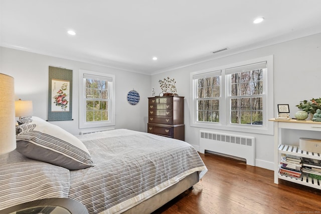 bedroom featuring recessed lighting, visible vents, wood finished floors, and radiator