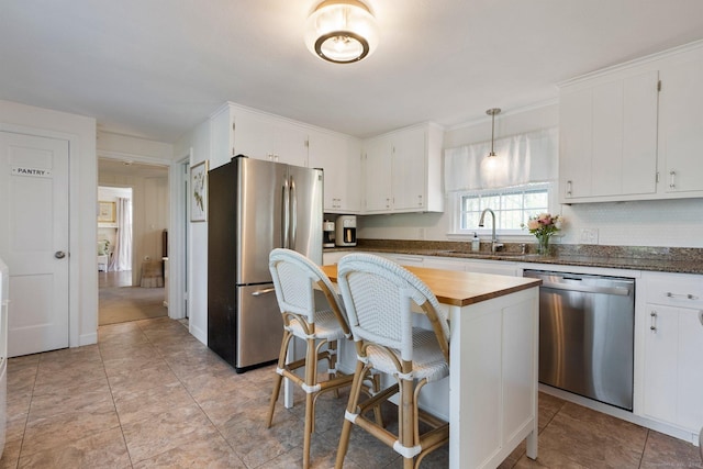 kitchen with a sink, stainless steel appliances, and white cabinetry