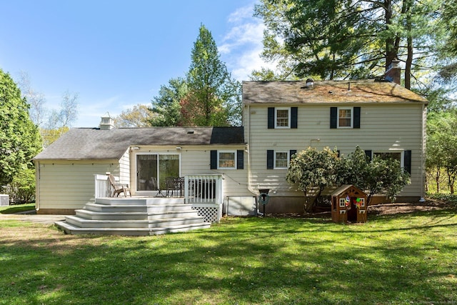 rear view of house with a chimney, a yard, and a deck