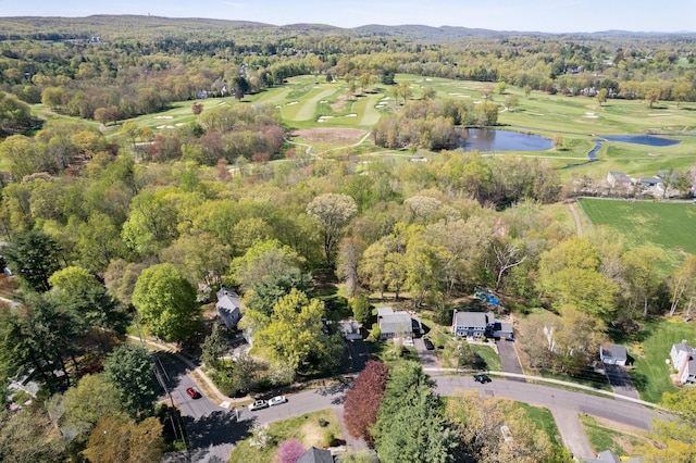 bird's eye view featuring a water view, view of golf course, and a forest view