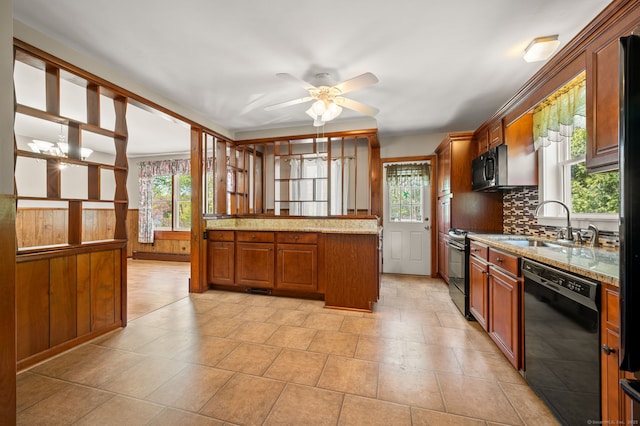 kitchen featuring brown cabinets, a sink, a ceiling fan, decorative backsplash, and black appliances