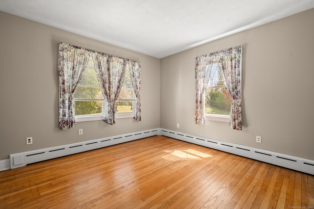 unfurnished room featuring a healthy amount of sunlight and hardwood / wood-style flooring