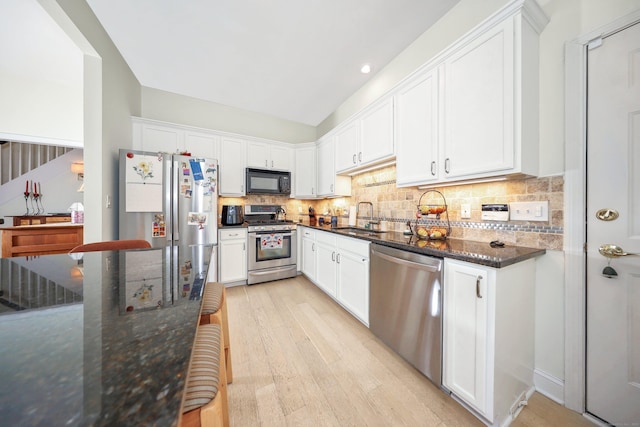 kitchen with white cabinetry, appliances with stainless steel finishes, a sink, and light wood-type flooring