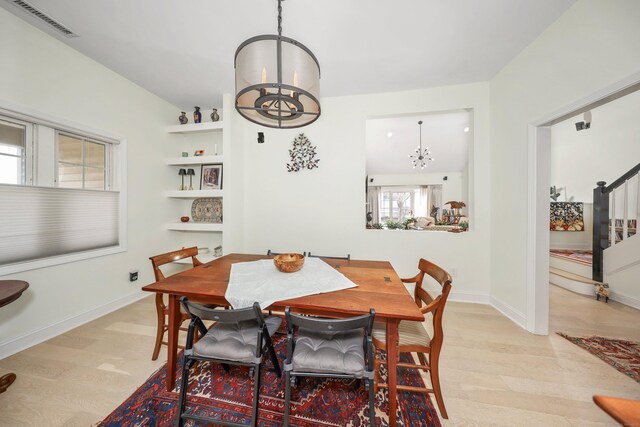 dining room featuring visible vents, baseboards, a chandelier, and stairway