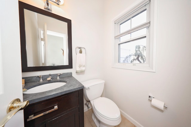 bathroom with vanity, baseboards, tile patterned flooring, and toilet