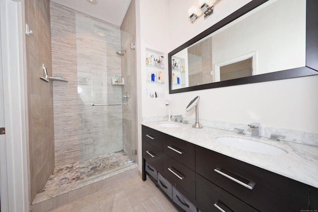 full bathroom featuring double vanity, a shower stall, and a sink