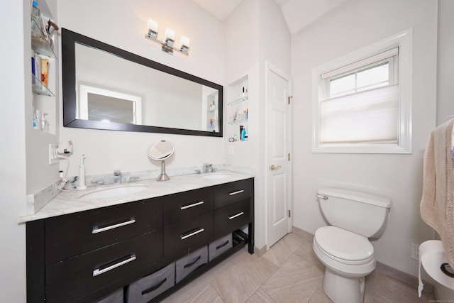 full bathroom featuring double vanity, a sink, and toilet