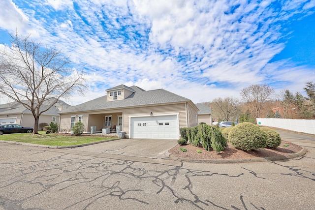 traditional-style house featuring fence, an attached garage, and driveway