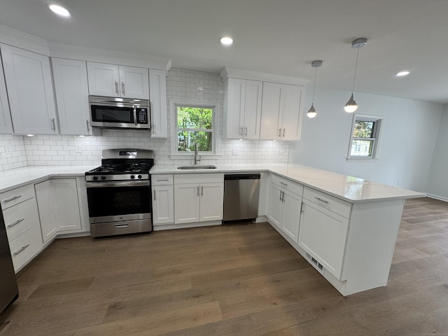 59 Fairfax St, Waterbury, CT 06704 - kitchen with stainless steel appliances, a sink, a peninsula, white cabinets, and backsplash