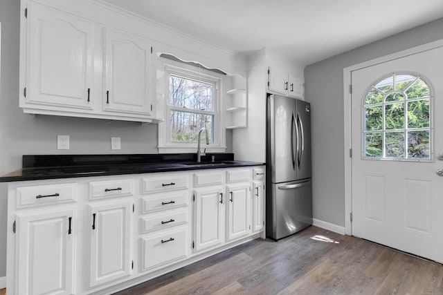 kitchen with plenty of natural light, freestanding refrigerator, a sink, and wood finished floors