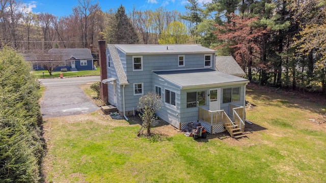 back of property featuring a yard, a chimney, and entry steps