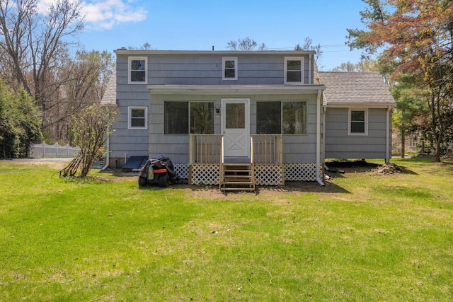 rear view of property with fence and a yard
