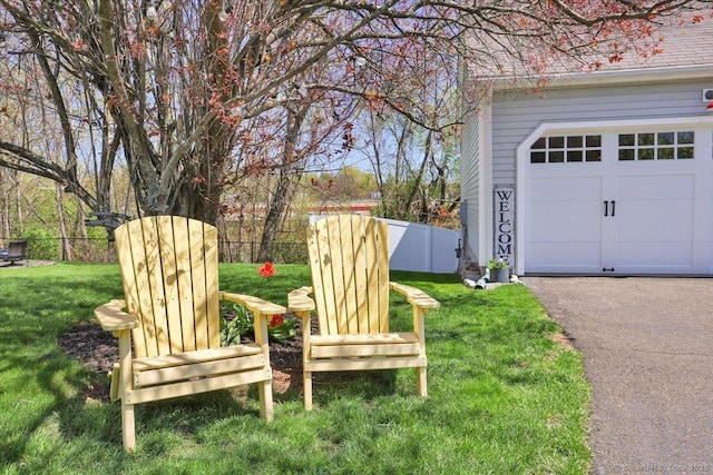 view of yard featuring a garage and fence