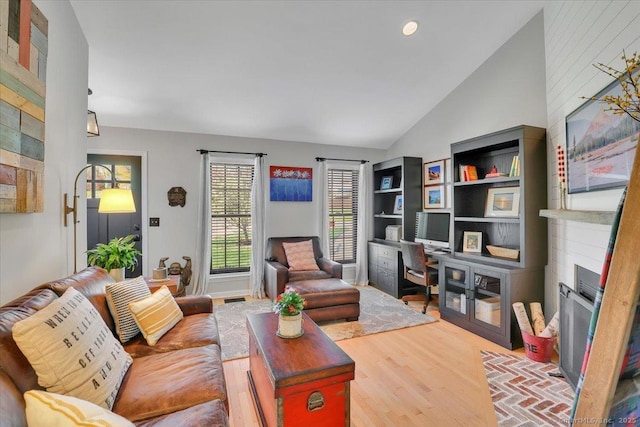 living area with a fireplace, recessed lighting, wood finished floors, and lofted ceiling