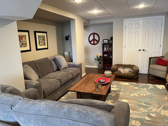 living room with baseboards, dark wood-style floors, and a paneled ceiling