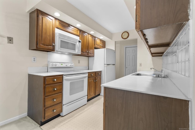 kitchen with white appliances, a sink, recessed lighting, light countertops, and baseboards