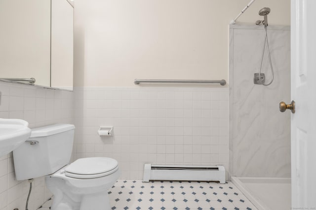 full bath featuring baseboard heating, tile walls, a shower stall, toilet, and wainscoting