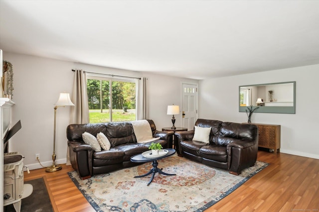 living area with baseboards and wood finished floors