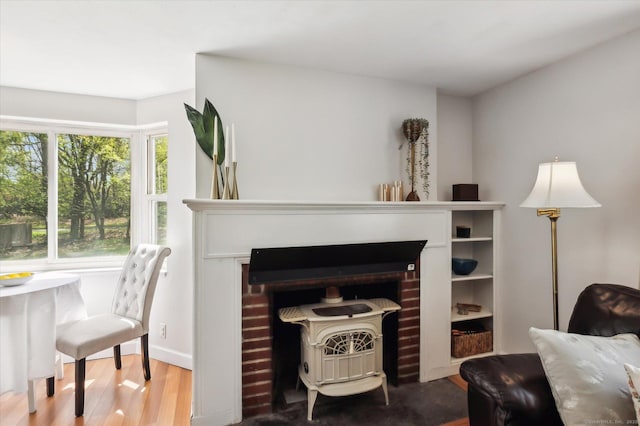 living area with a wood stove and wood finished floors