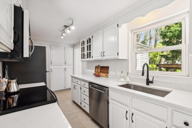 kitchen featuring dishwasher, a sink, light tile patterned floors, white cabinets, and light countertops