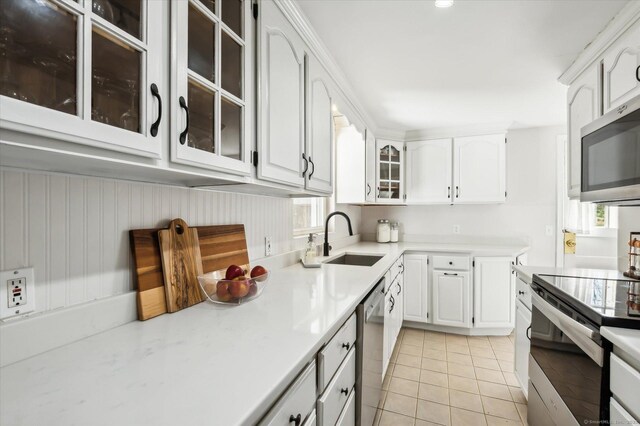 kitchen featuring a sink, light tile patterned floors, stainless steel appliances, and light countertops
