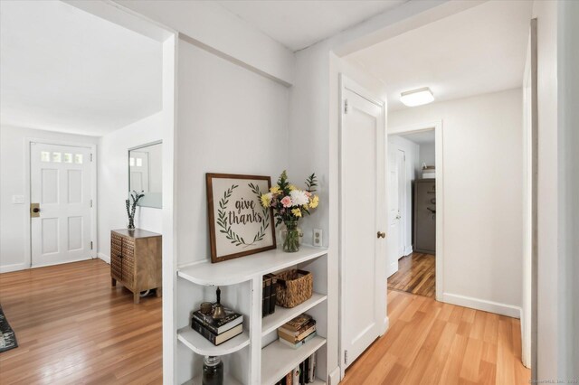 hallway with baseboards and light wood-type flooring
