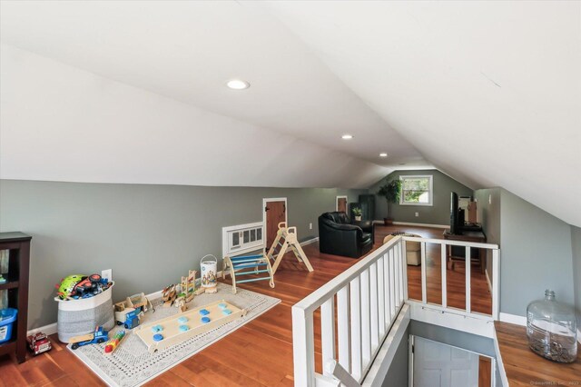 game room featuring baseboards, wood finished floors, and vaulted ceiling