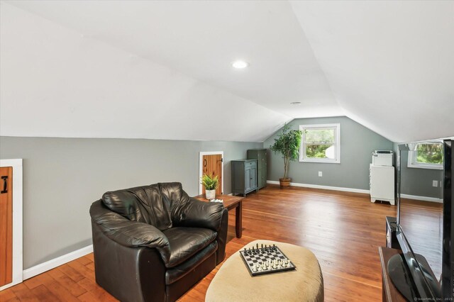 sitting room with baseboards, lofted ceiling, and wood finished floors