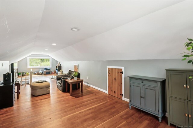 additional living space with baseboards, vaulted ceiling, and wood finished floors