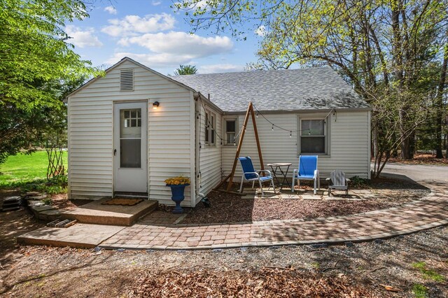 back of property with a shingled roof