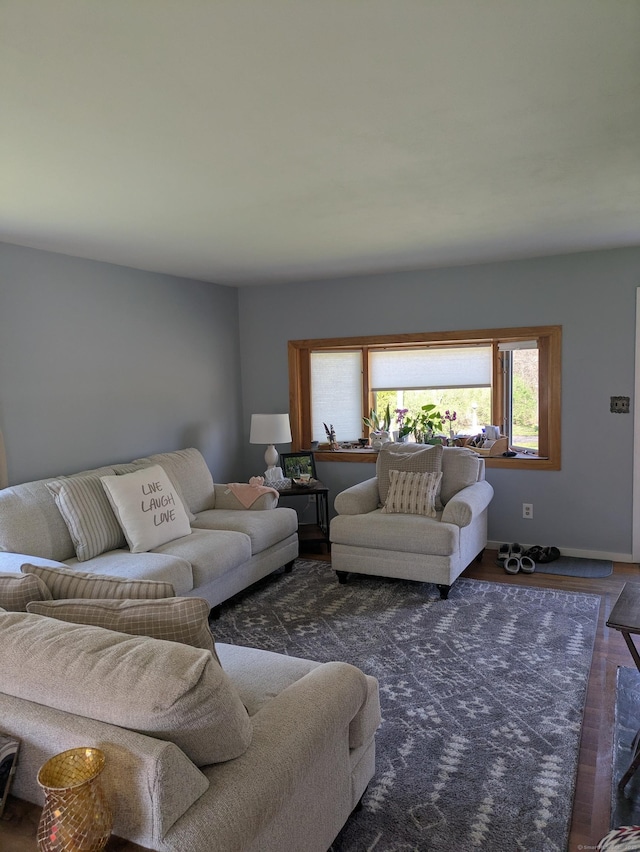 living area with baseboards and wood finished floors