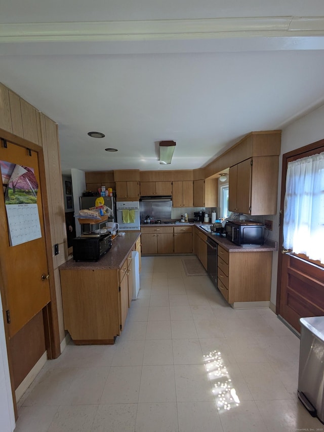 kitchen featuring brown cabinets, black appliances, and range hood