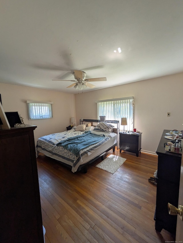 bedroom with ceiling fan, hardwood / wood-style floors, and multiple windows