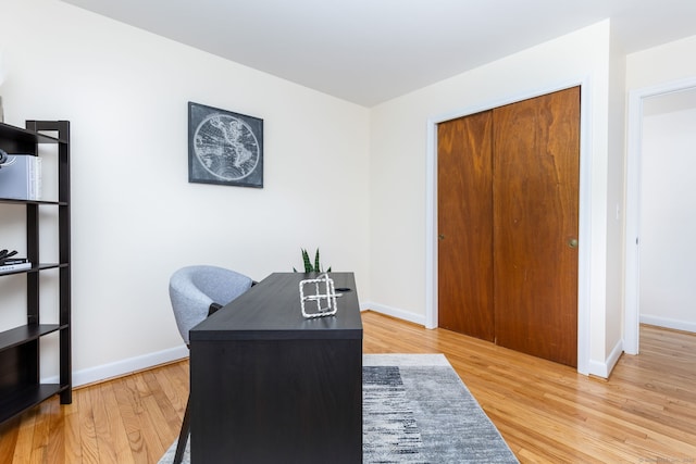 home office with baseboards and wood finished floors