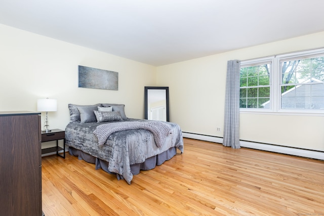 bedroom featuring wood finished floors and a baseboard radiator