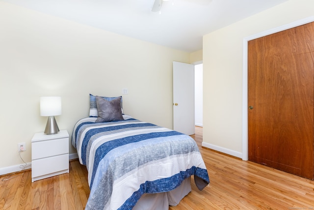 bedroom with light wood finished floors, baseboards, and ceiling fan