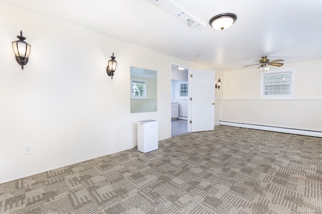 carpeted spare room featuring baseboard heating and ceiling fan