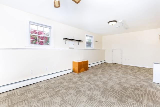 empty room with a baseboard radiator, carpet floors, a ceiling fan, and baseboards