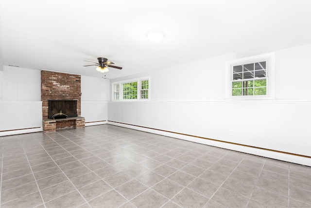 unfurnished living room featuring a ceiling fan, a baseboard radiator, a wainscoted wall, a baseboard heating unit, and a fireplace