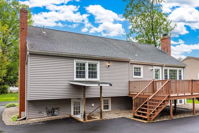 back of house with a wooden deck, a chimney, a patio, and stairway
