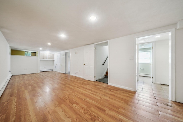 below grade area featuring a baseboard radiator, recessed lighting, and light wood-style flooring