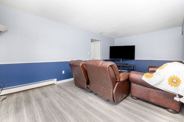 living area featuring baseboards, a baseboard heating unit, and wood finished floors