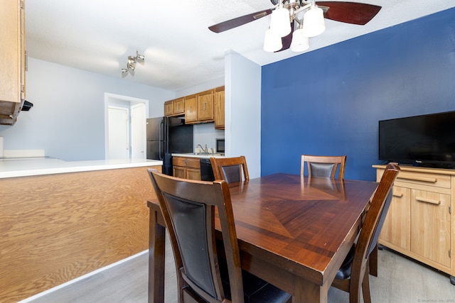 dining room with a ceiling fan and light wood-type flooring