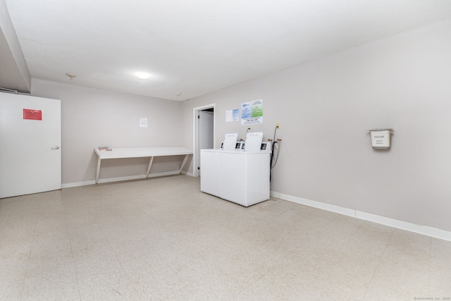 common laundry area with baseboards, light floors, and washer and clothes dryer