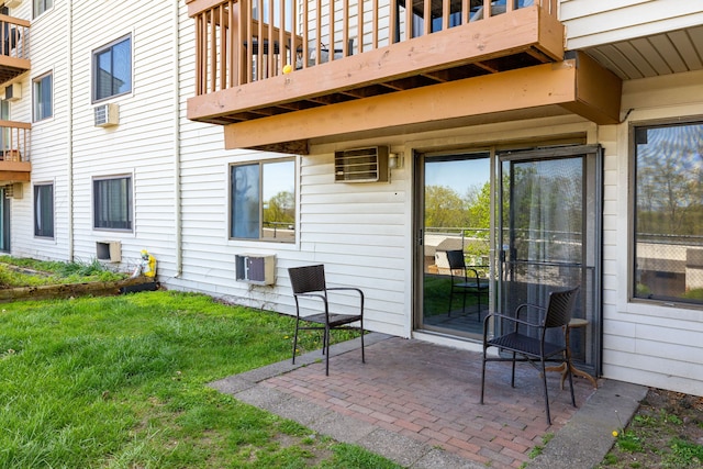 view of patio featuring an AC wall unit and a balcony