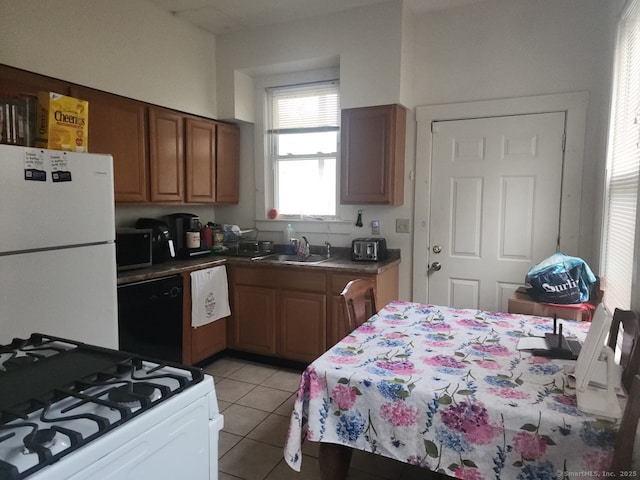 248-250 Howard Ave, New Haven, CT 06519 - kitchen with white appliances, a sink, light tile patterned floors, brown cabinets, and dark countertops