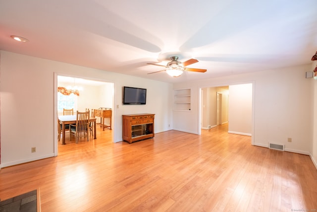 26 Converse Rd, Bolton, CT 06043 - unfurnished living room featuring ceiling fan, light wood-type flooring, baseboards, a chandelier, and built in features