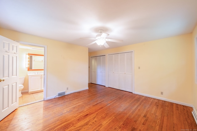 26 Converse Rd, Bolton, CT 06043 - unfurnished bedroom featuring multiple closets, light wood-type flooring, baseboards, and a baseboard radiator