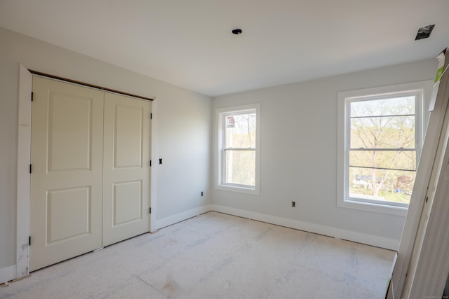 unfurnished bedroom with baseboards and a closet