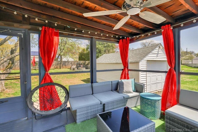 sunroom / solarium with ceiling fan, an outdoor living space, a healthy amount of sunlight, and beam ceiling